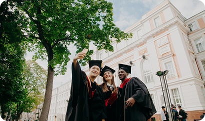 Three graduates taking a selfie together.